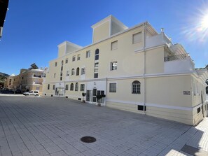 Ein mehrstöckiges Gebäude mit flacher Fassade, großen Fenstern und einem zentralen Eingang.