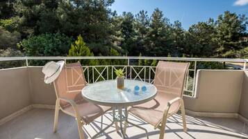 Ein Balkon mit zwei Stühlen, einem kleinen Tisch und einem Blumentopf.
