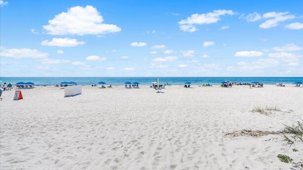 A beach with clear skies, sand, and a few umbrellas. - Snowbird-Friendly 3BR Gulf Shores Home Near Beach (Gulf Shores)