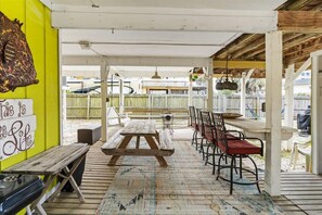 Eine Terrasse im Freien mit Holztisch und -stühlen, einer Bank und einem Schild an der Wand.
