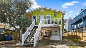 A two-story building with a balcony, a staircase, and a sign that reads '1033'. - Snowbird-Friendly 3BR Gulf Shores Home Near Beach (Gulf Shores)