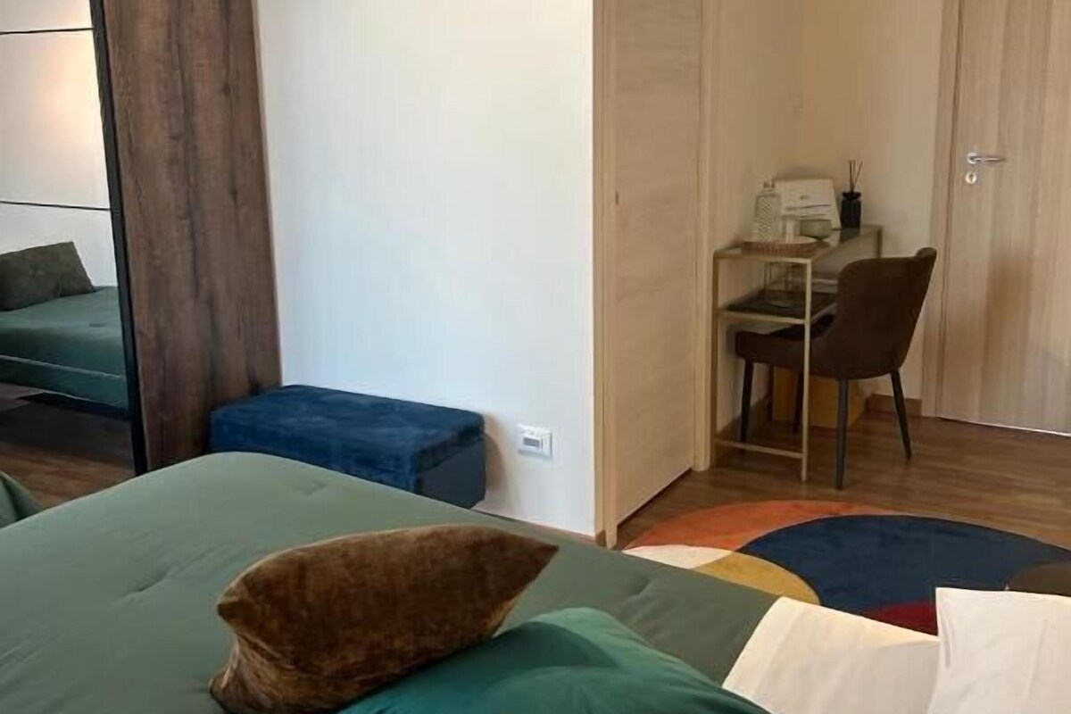 A bedroom with a bed, a desk, a chair, and a wardrobe.