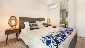 Ein Schlafzimmer mit einem Bett, Nachttischlampen, einem Spiegel und einem Kleiderschrank.