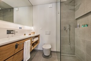 Ein modernes Badezimmer mit Dusche, Toilette und Waschtisch mit Spiegel.