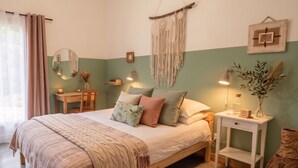 A bedroom with a bed, bedside tables, a mirror, wall art, and a window with curtains. - Family B&B in the heart of the horses (Jouques)