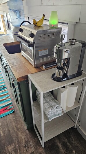 Eine Küche mit Kaffeemaschine, Wasserspender und einer Banane auf der Arbeitsfläche.