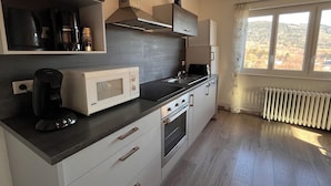Een moderne keuken met een magnetron, koffiezetapparaat en broodrooster.