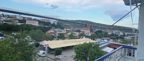 A balcony with a view of a town, including buildings and a bridge.