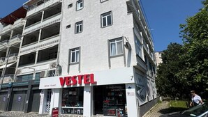 A multi-story building with a storefront labeled 'VESTEL' and a sign indicating 'BERIVAN TICARET'. - Beluna City Apart (Marmara)