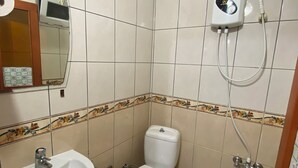A bathroom with a toilet, sink, and a hand dryer mounted on the wall. - Beluna City Apart (Marmara)