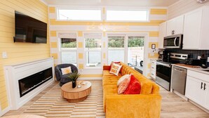 Un salon moderne avec une cheminée, un canapé et une table basse.