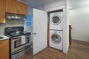 A compact kitchen with a stove, oven, and a built-in washer and dryer. - HNU  · HNU  NEWLY Decorated 2 Bedroom + Den Apartment (Kitchener)