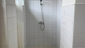 Chuveiro, toalhas de banho, sabonete, papel higiênico
