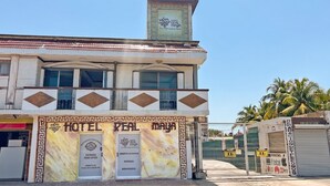 A hotel named 'Hotel Real Maya' with a sign indicating 'Entrada' and 'Abierto 24 Horas.'