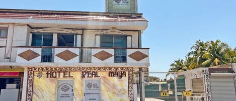 A hotel named 'Hotel Real Maya' with a sign indicating 'Entrada' and 'Abierto 24 Horas.'