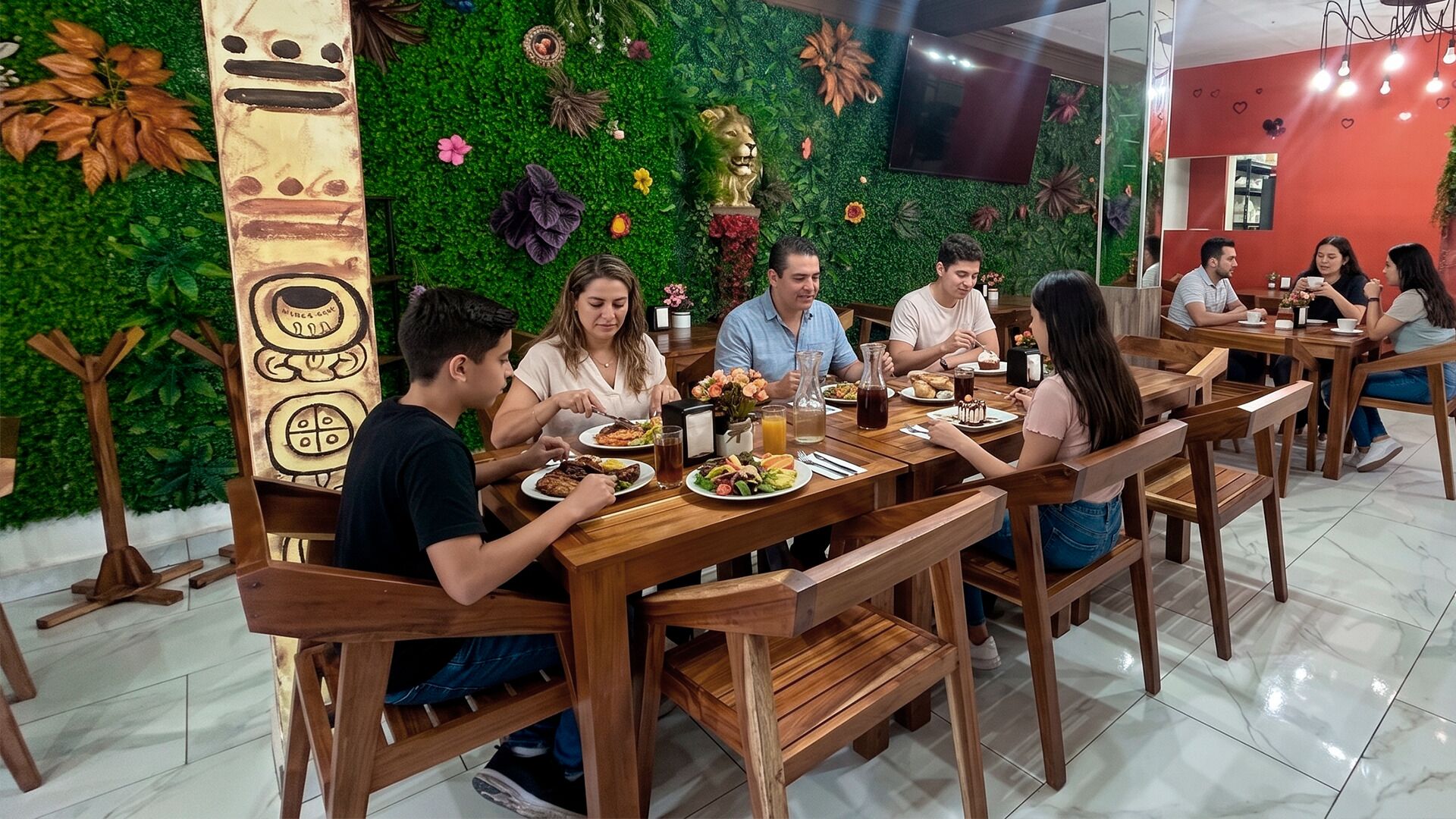 A restaurant with wooden tables and chairs, a green wall with plants, and a decorative lion statue.