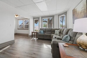 A living room with a sectional sofa, a small table, and a lamp.