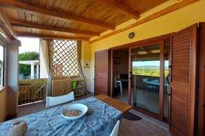 A covered patio with a table, chairs, and a view of the countryside. - LU CANALEDDU - BUDONI SWEET HOME (Agrustos)