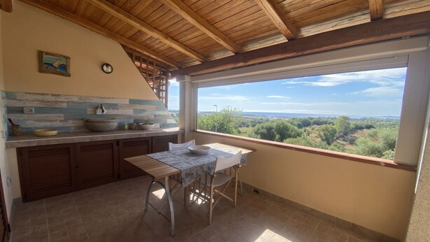 Una cocina con techo de madera, una mesa de comedor y vistas al campo.