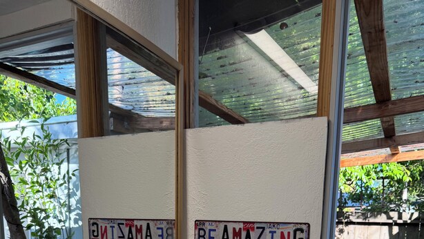 Un baño con un lavabo blanco, un espejo y dos placas de matrícula en la pared.