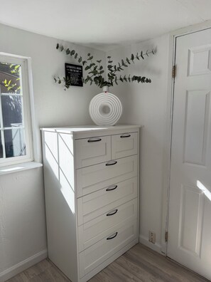 A white dresser with drawers and a vase with green leaves on top. - Private fenced guesthouse perfect for a couple, near Stanford, Google, Facebook (Palo Alto)