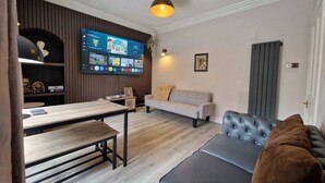 Un salon avec un téléviseur, un canapé et une table à manger.