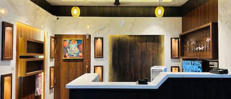 A reception area with a marble counter, wooden paneling, and a ceiling with exposed beams.