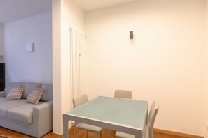 Ein Zimmer mit einer Couch, einem Tisch und Stühlen.