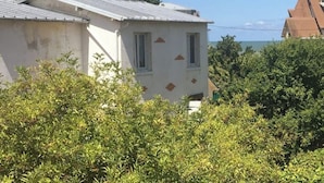 Un bâtiment doté d’un toit en pente, de deux fenêtres et d’une porte partiellement visible.