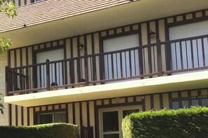 Ein zweistöckiges Gebäude mit Balkon, Fensterläden und einem Schild, auf dem 'LE CLOS' steht.