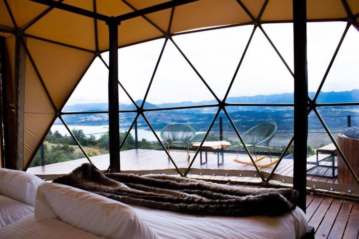 Tienda de campaña con cama y vistas al paisaje.