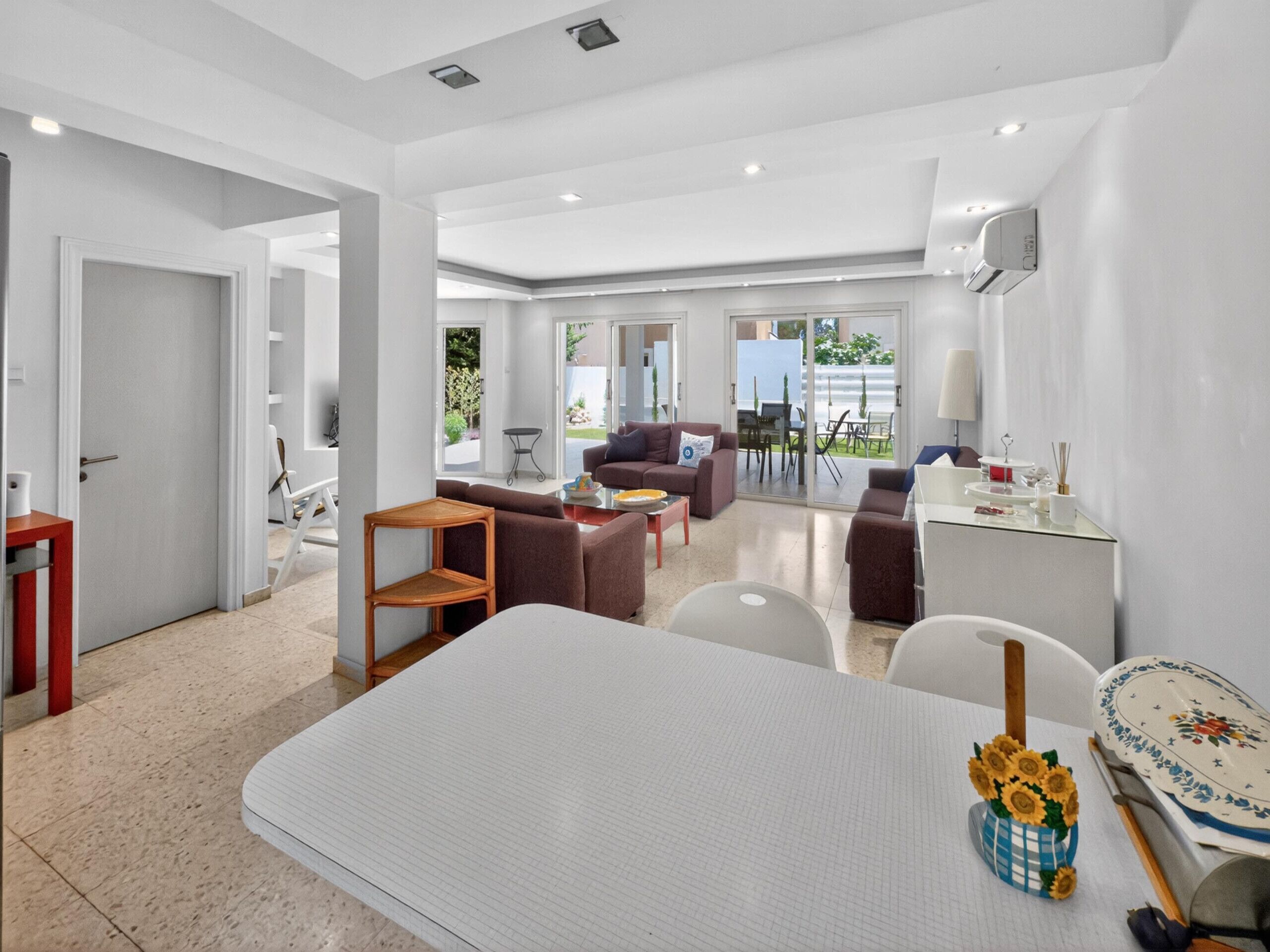 Ein modernes Wohnzimmer mit einer Couch, einem Couchtisch und einem Essbereich mit Stühlen.