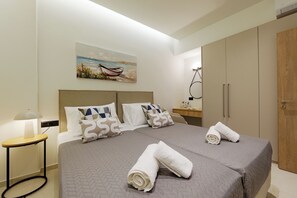 Ein Hotelzimmer mit Bett, Nachttisch, Lampe, Gemälde und Kleiderschrank.