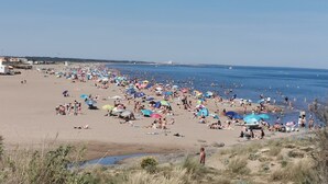 A crowded beach with people sunbathing and swimming, a lifeguard tower, and a clear sky. - Gîte des Tamarins - Saint-Pierre la Mer - Aude (Fleury)