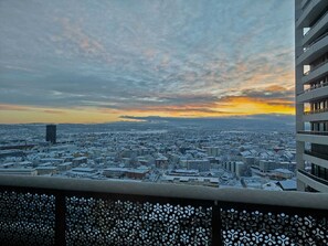 A cityscape with snow-covered buildings and a sunset. - 24th-Floor 3-bed room near Zurich, wrap-around Balcony, Parking & Stunning Views (Dübendorf)