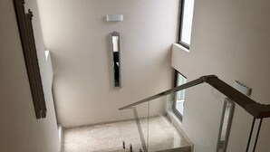 A modern staircase with glass railings, a marble floor, and a minimalist design. - Sea Walk Villa (Баку)