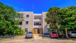 A modern two-story building with a flat roof, a central entrance, and a small balcony on the upper floor. - Quiet, Near Beaches Cenotes, Ruins | Pool, Rooftop Hot Tub, Jungle & Ocean Views (Akumal)