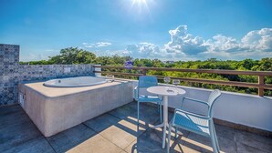 A rooftop terrace with a hot tub, two chairs, and a table under a clear sky. - Quiet, Near Beaches Cenotes, Ruins | Pool, Rooftop Hot Tub, Jungle & Ocean Views (Akumal)