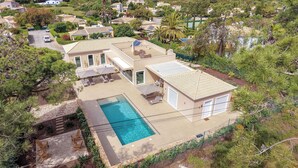 Ein Wohnhaus mit Swimmingpool, Sitzgelegenheiten im Freien und Blick auf die umliegende Nachbarschaft.