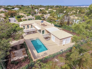 Ein Wohnhaus mit Swimmingpool, Sitzgelegenheiten im Freien und Blick auf die umliegende Nachbarschaft.
