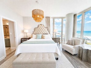 Ein geräumiges Schlafzimmer mit großem Bett, einer Sitzecke und Blick auf den Strand.