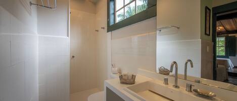 A bathroom with a shower, toilet, and sink.