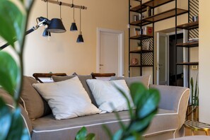 Ein Wohnzimmer mit einer Couch, einem Bücherregal und Pendelleuchten.