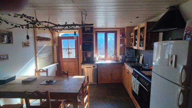 Una cucina compatta con mobili in legno, un fornello, un lavello e una finestra.