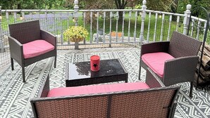 An outdoor patio with wicker furniture and a patterned floor. - October in Boston - Jamaica Plain Home Near Hospitals & New England Adventures (Boston)