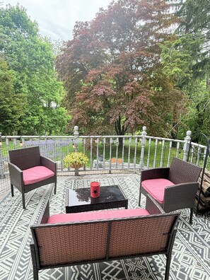 Eine Terrasse im Freien mit Korbmöbeln und einem gemusterten Boden.