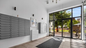 Um interior moderno com uma grande porta de vidro que dá para o exterior, um armário fixado na parede e piso revestido de azulejos.