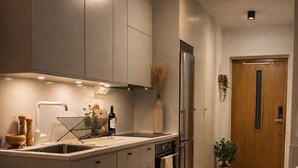 Une cuisine moderne avec un coin repas, un plancher en bois et une porte en bois.