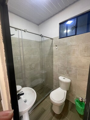 Een douche, handdoeken, zeep, toiletpapier