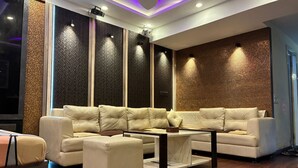 Uma sala de estar moderna com um sofá modular, uma mesa de centro e uma parede texturizada.